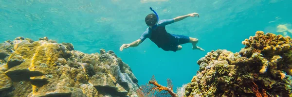 Hombre feliz en buceo máscara de snorkel bajo el agua con peces tropicales en la piscina de coral de arrecife de mar. Estilo de vida de viajes, deportes acuáticos aventura al aire libre, clases de natación en vacaciones de verano. Vista aérea desde — Foto de Stock