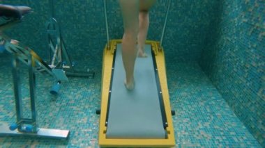 Kuala Lumpur, Malezya - 25 Nisan 2018. Sualtı su koşu bandında egzersiz yapan genç bir kadının yavaş çekim çekimi. Aqua spor egzersizleri kavramı