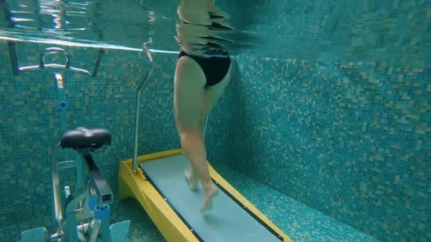 Kuala Lumpur, Maleisië-25 april 2018. Slowmotion shot van een jonge vrouw die oefeningen doet op een onderwater Aqua loopband. Aqua sportoefeningen concept — Stockvideo