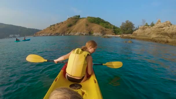 Filmagem em câmera lenta de uma jovem família de caiaque em um mar tropical e se divertindo olhando para recifes de corais e peixes tropicais subaquáticos. Ya Nui Beach na ilha de Phuket — Vídeo de Stock