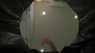 Bir çöp kutusundan görünüm - adam çöp kutusuna çöp atar. Plastik atık kavramı. Aşırı atık kavramı