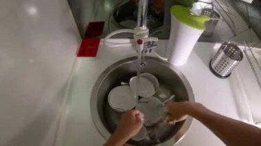 Mutfakta tabak ve gözlük yıkayan bir adamın bakış açısı
