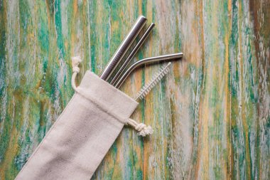 Çelik pipetler boyalı ahşap arka planda. Sıfır atık