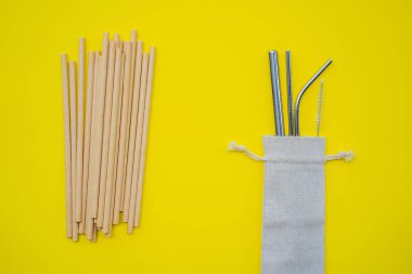 Sarı arka planda çelik içki ve tek kullanımlık pipetler. Sıfır atık