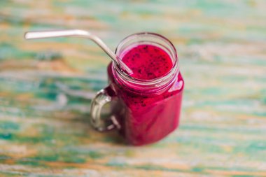 Boyalı ahşap arka plan üzerinde çelik içme saman ile Dragon meyve yüzlü