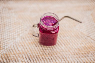 Bir saman arka plan üzerinde bir çelik içme saman ile Dragon meyve yüzlü