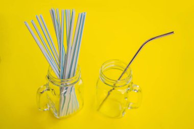 Sarı arka planda çelik içki ve tek kullanımlık pipetler. Sıfır atık