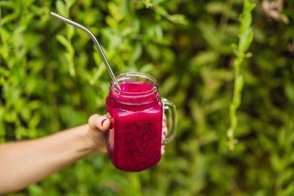 Frullato di frutta drago con paglia da bere in acciaio nelle mani femminili — Foto Stock