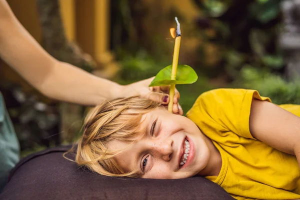 O menino recebe um procedimento com uma vela de ouvido, saúde de orelhas de crianças, boa audição, cera de ouvido — Fotografia de Stock