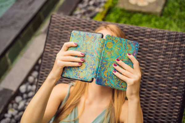 Vrouw leest e-book op terrasstoel in de tuin — Stockfoto