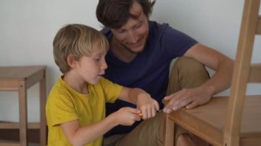 Baba ve küçük oğlu mobilya topluyorlar. Mutfak sandalyelerini bir araya getiriyorlar.