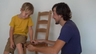 Baba ve küçük oğlu mobilya topluyorlar. Mutfak sandalyelerini bir araya getiriyorlar.