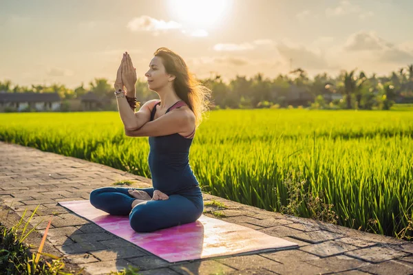 Fiatal nő gyakorlat jóga szabadtéri a rizs mezők a reggel folyamán wellness retreat Bali — Stock Fotó