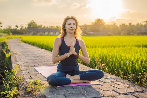 Fiatal nő gyakorlat jóga szabadtéri a rizs mezők a reggel folyamán wellness retreat Bali — Stock Fotó