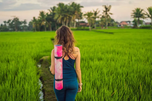 Mladá žena cvičím jógu venkovní v rýžových polích ráno během wellness retreat Bali — Stock fotografie