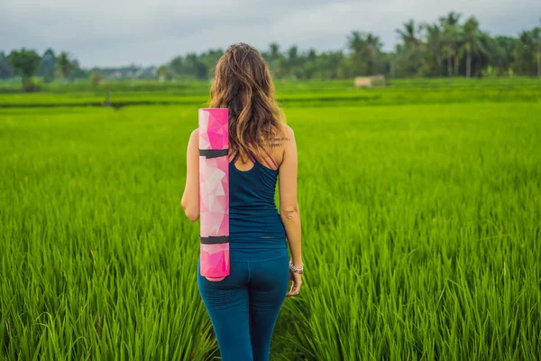 Mladá žena cvičím jógu venkovní v rýžových polích ráno během wellness retreat Bali — Stock fotografie