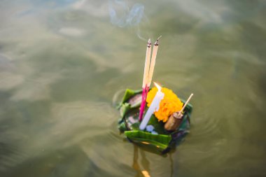 Loy Krathong festivali. İnsanlar Tayland 'daki Loy Krathong festivalini kutlamak için çiçek ve mum alıp suyun üzerinde yüzüyor.