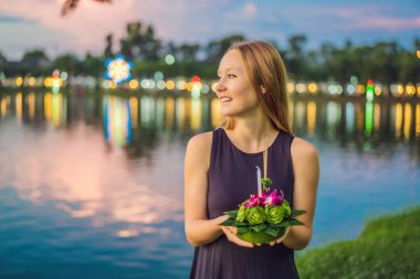 Bir kadın turist Elinde Loy Krathong tutar ve suya başlatmak üzeredir. Loy Krathong festivali, İnsanlar Loy kutlamak için ışık ve su üzerinde yüzen çiçek ve mum satın