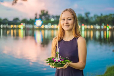 Bir kadın turist Elinde Loy Krathong tutar ve suya başlatmak üzeredir. Loy Krathong festivali, İnsanlar Loy kutlamak için ışık ve su üzerinde yüzen çiçek ve mum satın