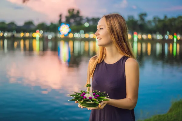 Kobieta turysta trzyma Loy Krathong w jej rękach i ma się uruchomić go w wodzie. Loy Krathong festiwalu, ludzie kupują kwiaty i świeczkę na światło i pływaka na wodzie, aby świętować Loy — Zdjęcie stockowe