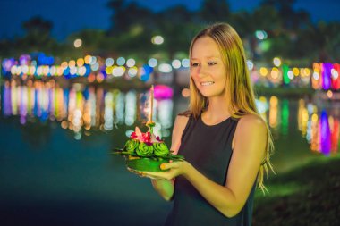 Bir kadın turist Elinde Loy Krathong tutar ve suya başlatmak üzeredir. Loy Krathong festivali, İnsanlar Loy kutlamak için ışık ve su üzerinde yüzen çiçek ve mum satın