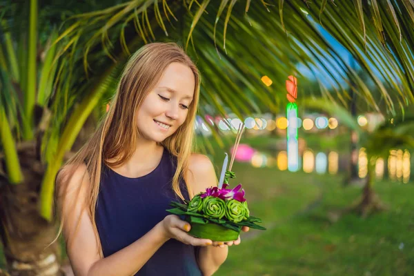 Uma turista feminina segura o Loy Krathong em suas mãos e está prestes a lançá-lo na água. Loy Krathong festival, as pessoas compram flores e velas para acender e flutuar na água para celebrar o Loy — Fotografia de Stock