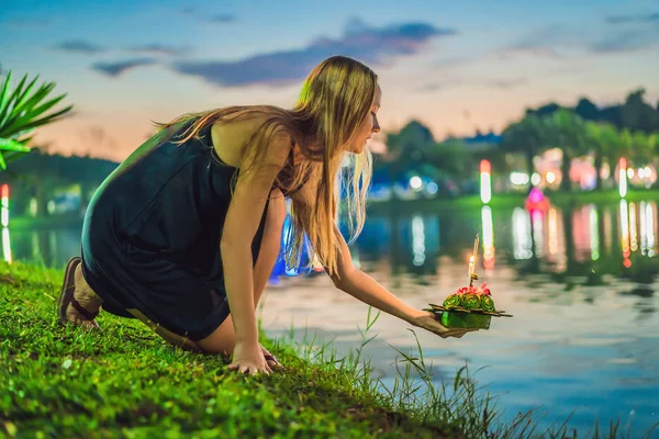 Жіночий турист тримає Лой Кратонг в руках і збирається запустити його у воду. Лой Кратонг фестиваль, люди купують квіти і свічку на світло і плавати на воду, щоб відсвяткувати Лой — стокове фото