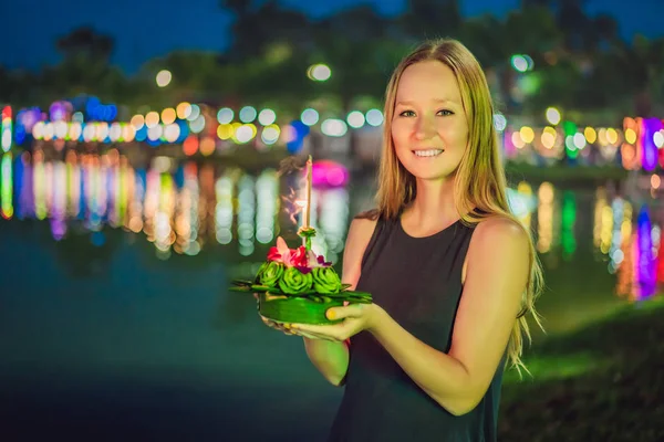 Bir kadın turist Elinde Loy Krathong tutar ve suya başlatmak üzeredir. Loy Krathong festivali, İnsanlar Loy kutlamak için ışık ve su üzerinde yüzen çiçek ve mum satın