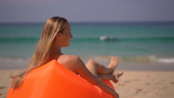 熱帯のビーチで膨らんだソファでくつろぐ若い女性のスーパースローモーションショット — ストック動画
