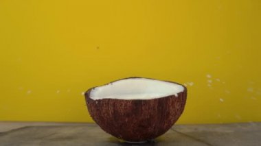 Tropik meyve küpleri sarı bir arka plan üzerinde bırakılan sonra hindistan cevizi sütü sıçramaları Superslowmotion çekim