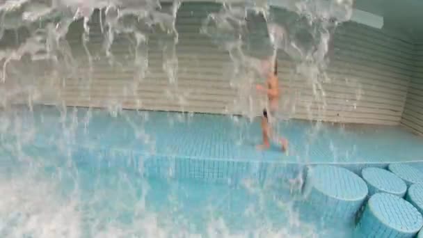 Повільний знімок маленького хлопчика розважається в басейні в парку — стокове відео