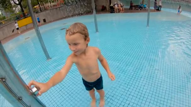一个小男孩在公园里游泳池里玩得开心的慢动作镜头 — 图库视频影像