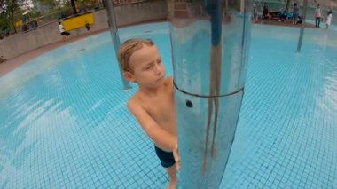 Parkta bir havuzda eğlenen küçük bir çocuğun slowmotion çekim