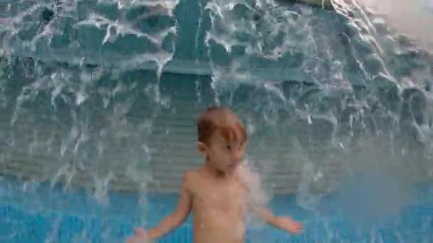 Slowmotion tiro de um menino se divertindo em uma piscina em um parque — Vídeo de Stock