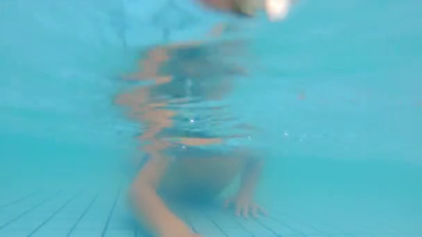 Pomenší záběr malého chlapce, který se baví v bazénu v parku — Stock video