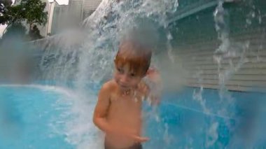 Parkta bir havuzda eğlenen küçük bir çocuğun slowmotion çekim