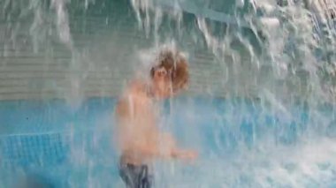 Parkta bir havuzda eğlenen küçük bir çocuğun slowmotion çekim