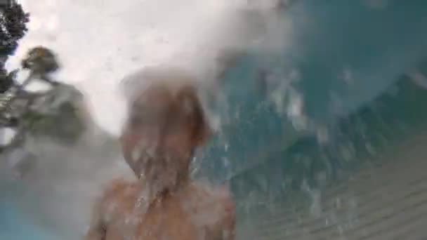 Plan au ralenti d'un petit garçon s'amusant dans une piscine dans un parc — Video
