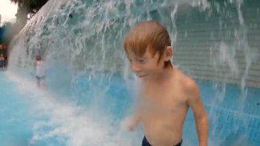 Parkta bir havuzda eğlenen küçük bir çocuğun slowmotion çekim