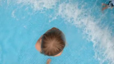 Parkta bir havuzda eğlenen küçük bir çocuğun slowmotion çekim