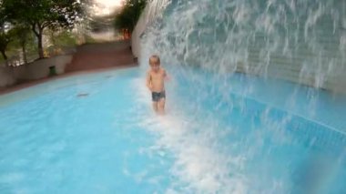 Parkta bir havuzda eğlenen küçük bir çocuğun slowmotion çekim