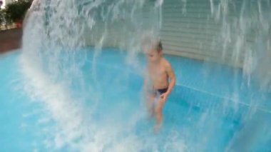 Parkta bir havuzda eğlenen küçük bir çocuğun slowmotion çekim