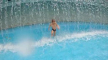 Parkta bir havuzda eğlenen küçük bir çocuğun slowmotion çekim