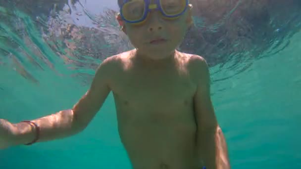 Повільний постріл маленького хлопчика занурення і бризкання в басейні — стокове відео