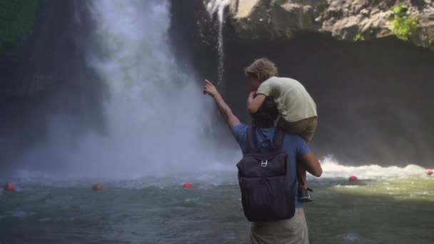 Slowmotion shot van vader en zoon een bezoek aan de Tegenungan waterval op het eiland Bali, Ubud — Stockvideo
