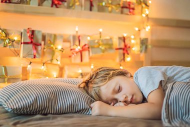 Küçük sarışın çocuk bir yatakta ve ev üzerinde uyuyan bir rafta gelişitakvim yaptı. Kış mevsimgeleneği. Kopyalama alanı