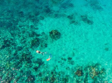 Mavi deniz okyanusunda şnorkelli yüzme ve mercan arka plan havadan üst görünümü çift