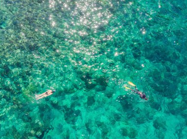 Mavi deniz okyanusunda şnorkelli yüzme ve mercan arka plan havadan üst görünümü çift