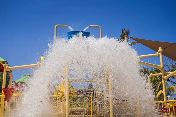 Bucket of water in water park. The main feature is a giant bucket that periodically dumps water all over the place