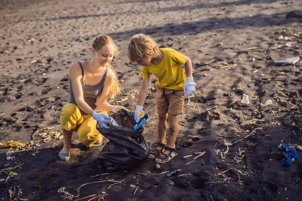 어머니와 아들 이 해변을 청소하고 있습니다. 어린이들의 자연 교육 — 스톡 사진